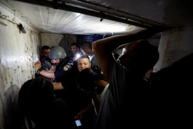 People take cover in a bomb shelter