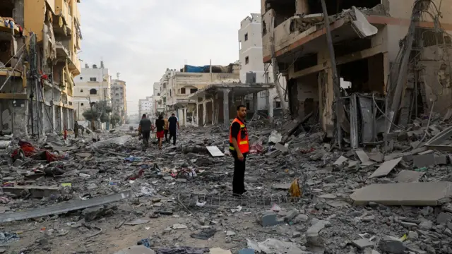 Rescuers stood in rubble in Gaza City