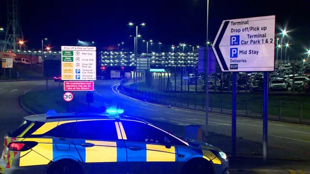 A police car blocks the road heading towards the terminals at Luton Airport.