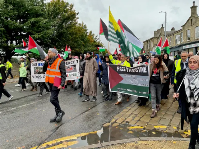 People march carrying Palestinian flags through the streets of Bradford