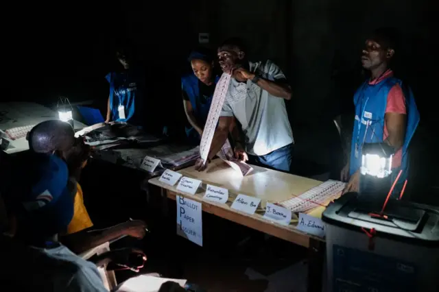 Election officials count the ballots of the general elections at a polling station in Monrovia on October 10, 2023.