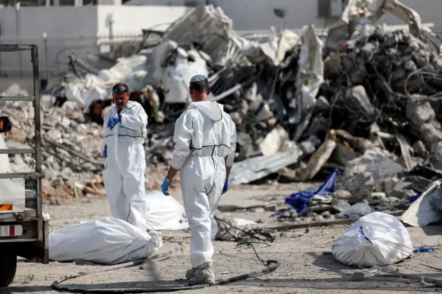 Workers cleaning up bodies