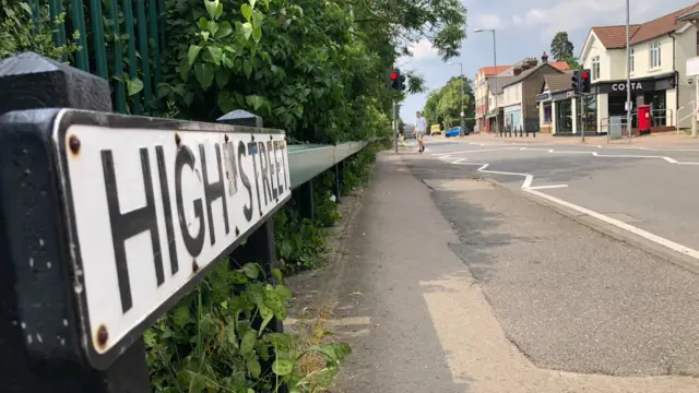 High Street sign in Flitwick, with shops in the background