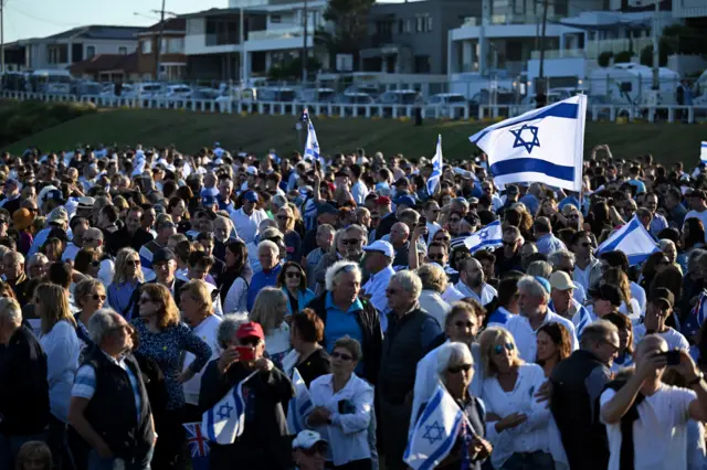 Hundreds of people with flags in white and blue