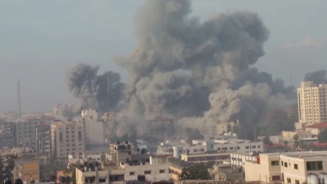 Plumes of smoke emanate from the grounds of the Islamic University in Gaza City after a strike by the Israeli Air Force