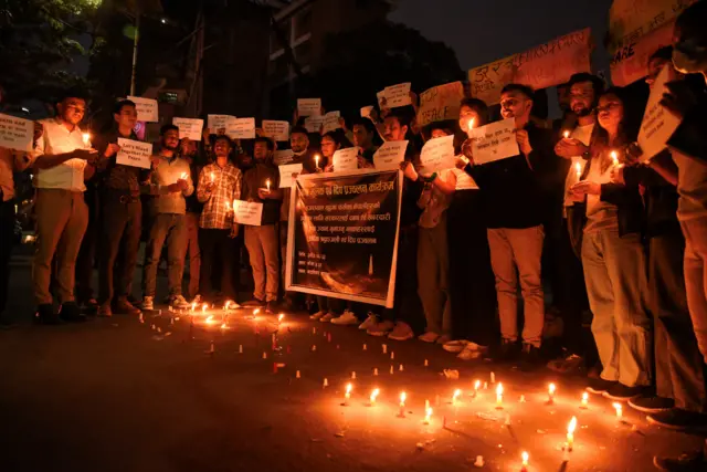 Students lined up holding signs and candles