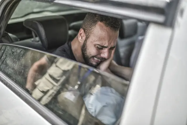 A Palestinian man cries while approaching a funeral ceremony of people killed in the airstikes