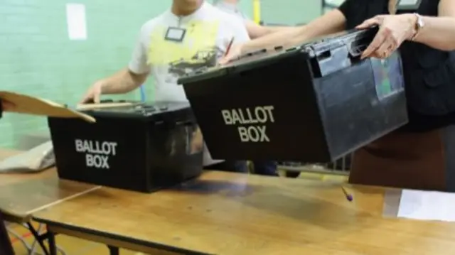 Ballot boxes being placed on a table at an election count