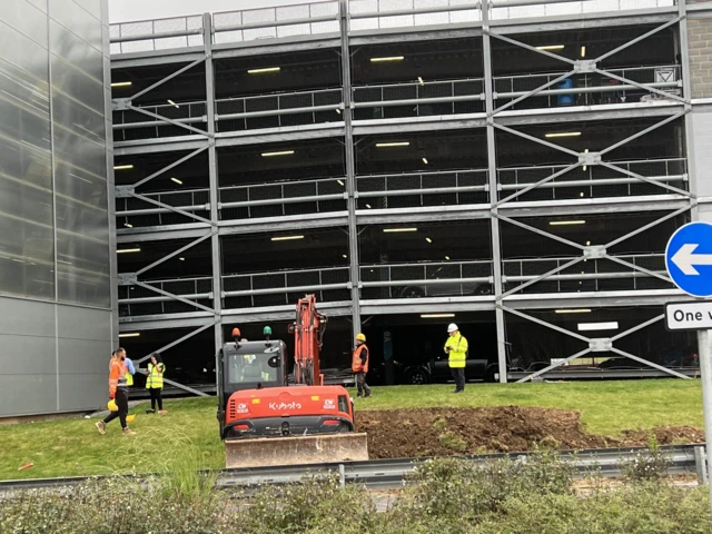 A digger is being used to create a new ramp at the car park to try and remove unaffected cars.