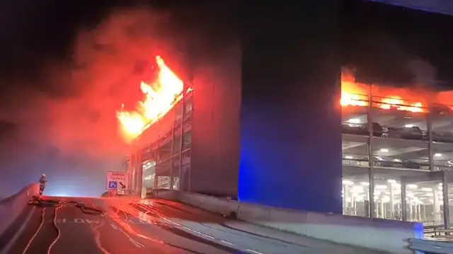 Flames bursting out of an upper level of a car park.