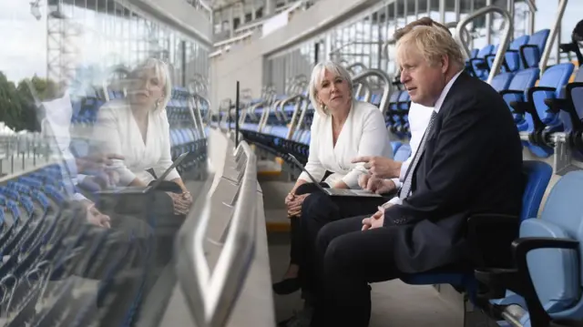 Nadine Dorries and Boris Johnson sitting in a stadium