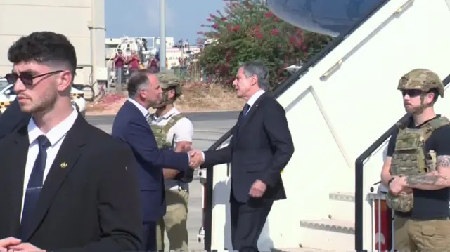 Antony Blinken shakes hands with an official in Tel Aviv