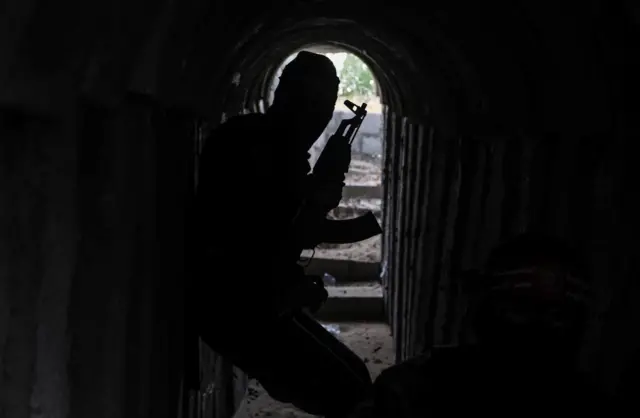 A silhouette of a soldier stands guard at tunnels in Gaza City