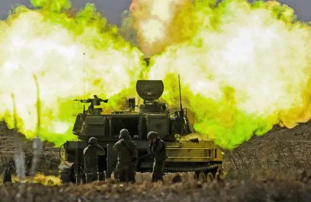 An IDF artillery unit fires towards Gaza. A huge ball of flames is visible