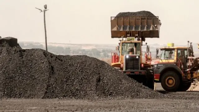 Pile of coal being scooped up.