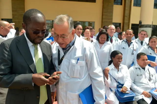 Kisumu Governor Professor Anyang Nyongo (L) talks to one of the 100 Cuban doctors following proceedings during their induction programme at the Kenya School of Government, on June 11, 2018 in Nairobi.