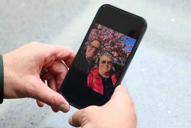 Noam Sagi views a recent family-taken photograph on his phone of himself with his mother Ada, who was kidnapped last week from a Kibbutz