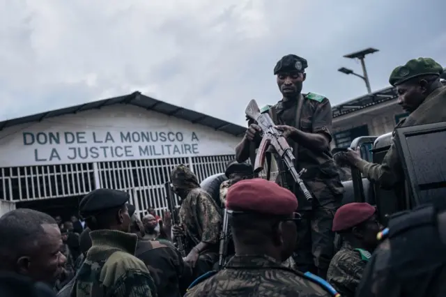 Soldiers escorting the six soldiers, charged with crimes against humanity and of violating orders, wait in a pick-up truck at the end of the hearing at the military court in Goma, eastern Democratic Republic of Congo, September 6, 2023.