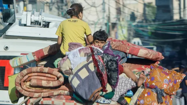 A boy sits among belongings in Gaza. 13 October 2023