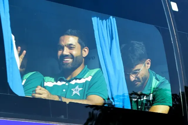 Pakistan's Mohammad Rizwan (L) gestures as Pakistan's team bus departs upon landing at the airport in Ahmedabad on October 11, 2023,