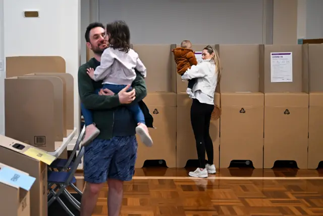 A 'vote yes' volunteer is seen at a voting centre in Brisbane, Australia, 14 October 2023. A