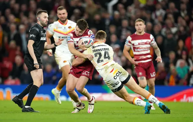 Tom Johnstone tackles Wigan's Jai Field