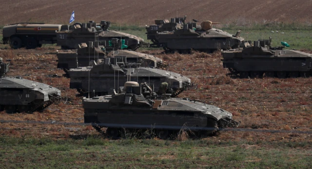 Israeli troops gather at an undisclosed location along the border with Gaza