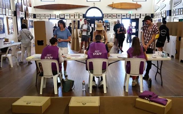 Voters talk to electoral officials inside a polling booth at Bondi Beach in Sydney