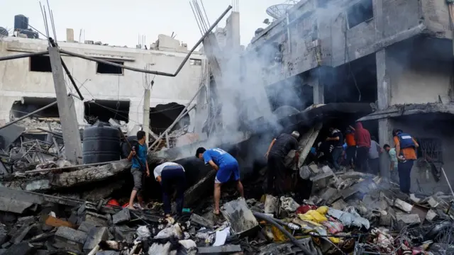 Palestinians search for casualties under the rubble in the aftermath of Israeli strikes