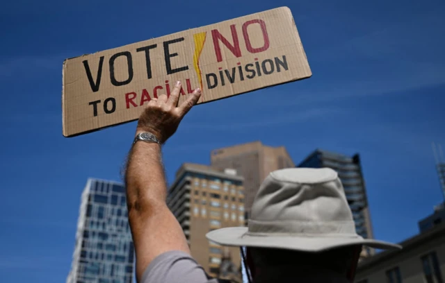 A No activist holds a placard reading 'Vote no to racial division' at a protest in Melboourne