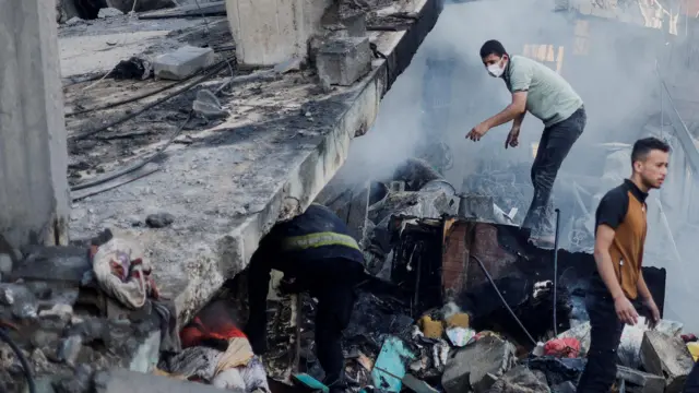 A Palestinian searches under the rubble in the aftermath of Israeli strikes on Gaza