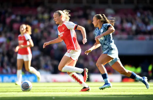 Frida Maanum of Arsenal runs with the ball whilst under pressure from Sarah Mayling