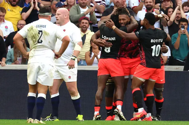 Fiji's outside centre and captain Waisea Nayacalevu  and teammates celebrate