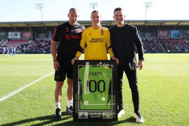 Earps is presented with a commemorative shirt for her 100th Utd appearance.