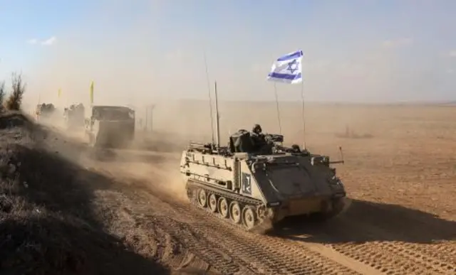 Israeli armoured personnel carriers (APCs) manoeuvre at an area along the border with Gaza