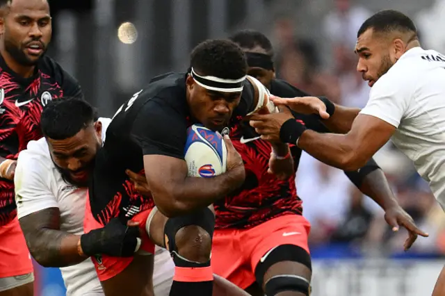 Fiji's right wing Vinaya Habosi is tackled by England's inside centre Manu Tuilagi