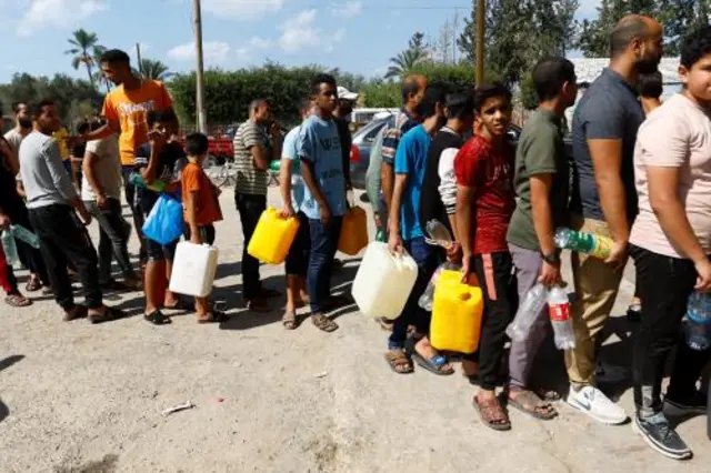 Palestinians wait to fill up their containers with petrol