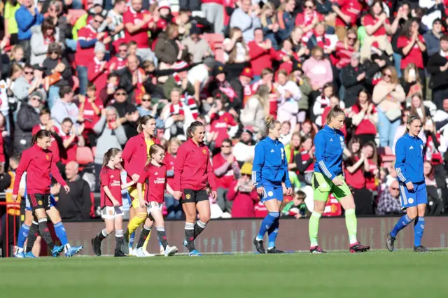 The teams make their way out onto the pitch before kick off.