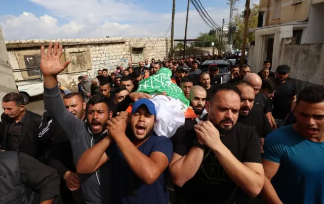 West Bank mourners carry the body of 16-year-old Mohamed Odwan who died during clashes with Israeli forces, Palestinian authorities said