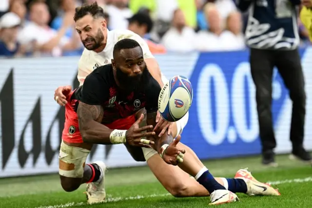 Fiji's left wing Semi Radradra is tackled by England's right wing Jonny May