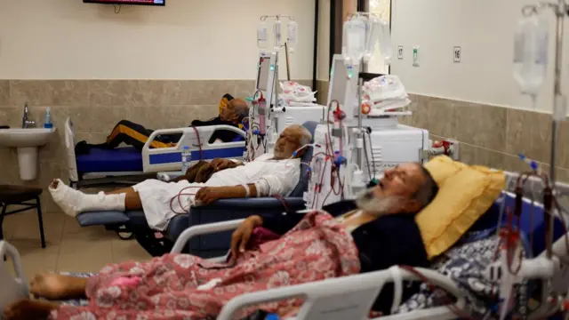 Palestinian patients lie on hospital beds in Khan Yunis