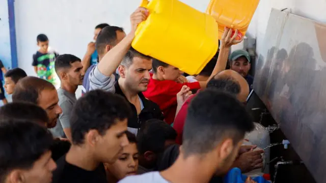 Palestinians gather to collect water, amid shortages of drinking water