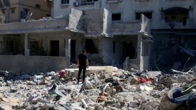 Man standing in rubble in Khan Younis