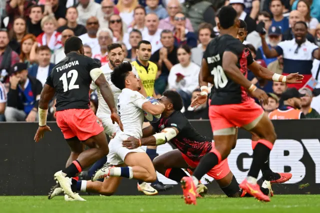 Marcus Smith of England falls to the ground after clashing heads with Vinaya Habosi of Fiji,