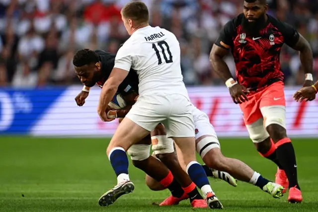 Fiji's flanker Lekima Tagitagivalu is tackled by England's fly-half and captain Owen Farrell