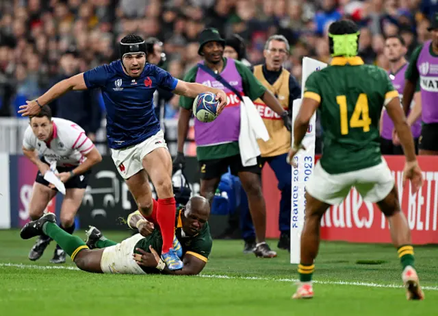 Antoine Dupont of France is tackled by Mbongeni Mbonambi