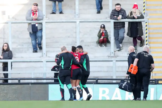 George is helped off the field by physios.