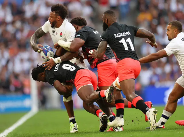 Courtney Lawes of England is tackled by Viliame Mata and Frank Lomani