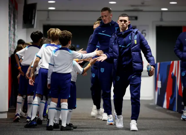 Foden high fives mascots when he arrives in the tunnel.