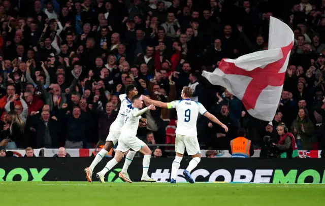 England players celebrate as a flag is waved in the crowd.